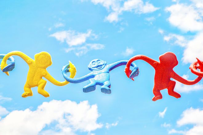Un grupo de monos de juguete unidos frente al cielo.