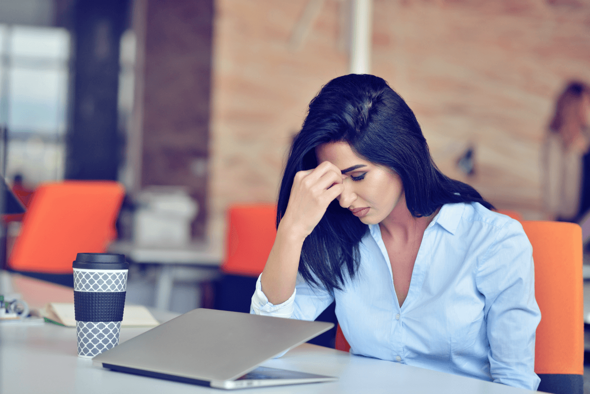 стресирана жена на работа с кафе и лаптоп