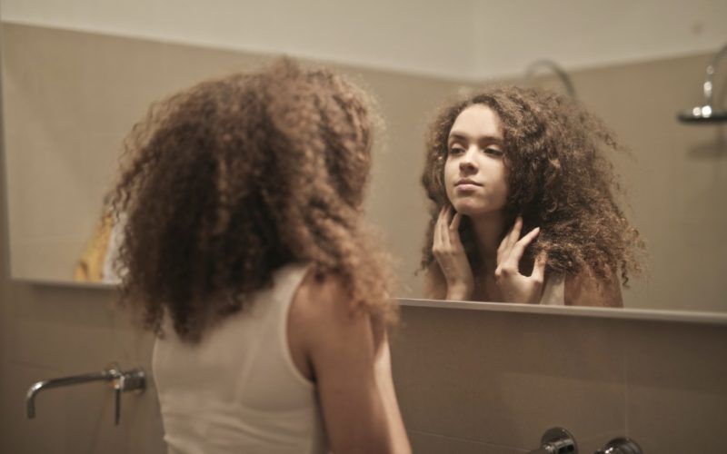 Жена гледа у огледало, слику тела