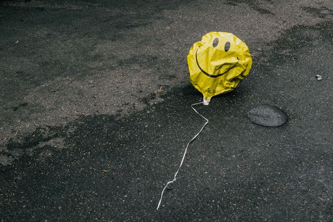 iztukšots dzeltens smaidiņu balons uz ielas