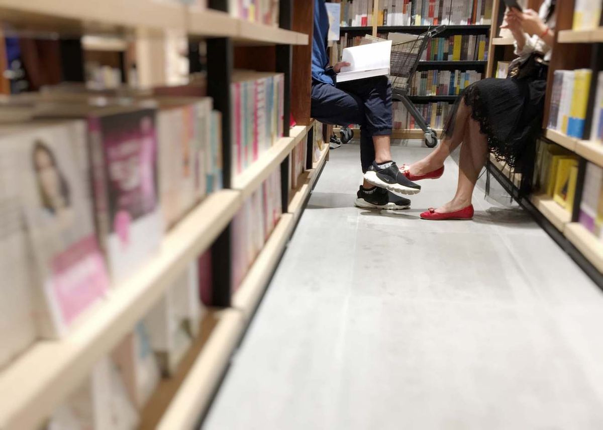 Покровителите на книжарниците четат книги на пътеката
