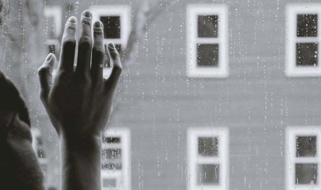жена с ръка, притисната към дъждовно стъкло