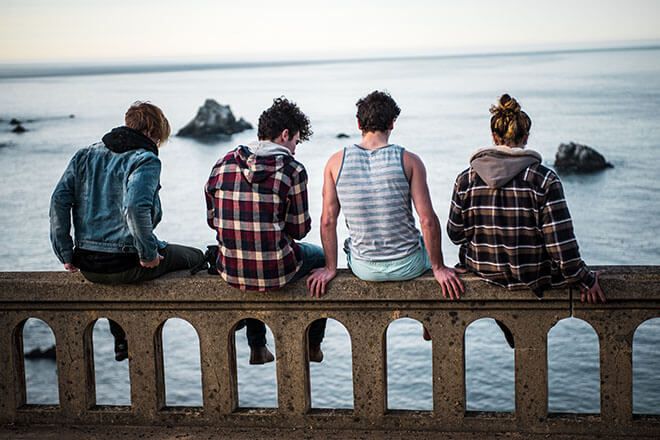 Teini-ikäiset istuvat sillalla