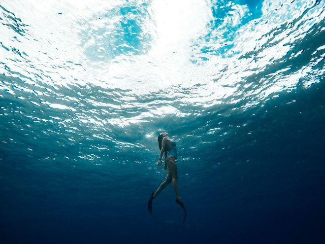 Sieviete peld uz okeāna virsmu