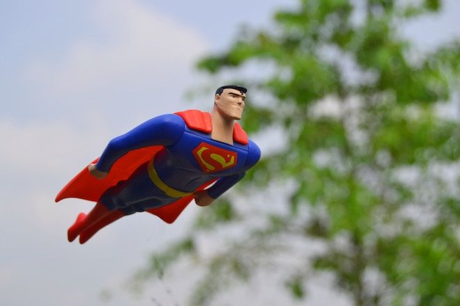 Супергерой се плъзга във въздуха по пътя си, за да спаси някого