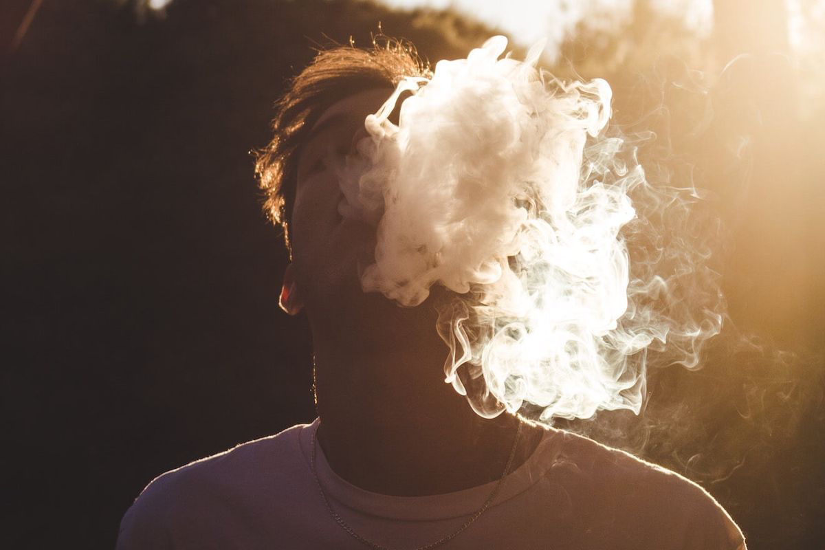 Dūmų debesį pučiantis žmogus