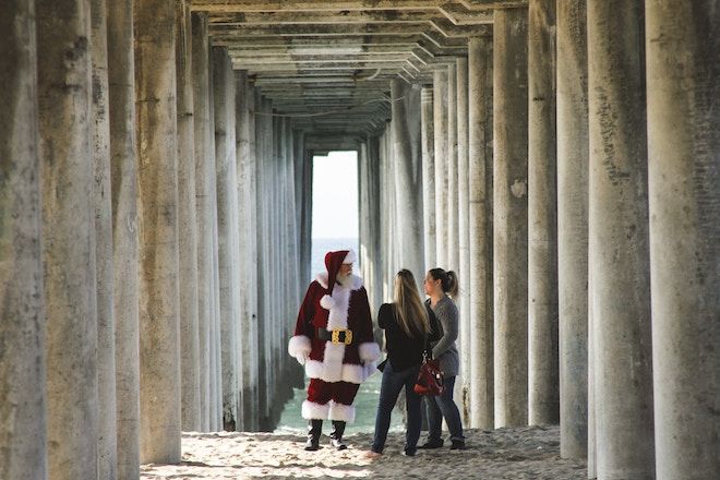Две жени се срещат с Дядо Коледа под калифорнийски кей