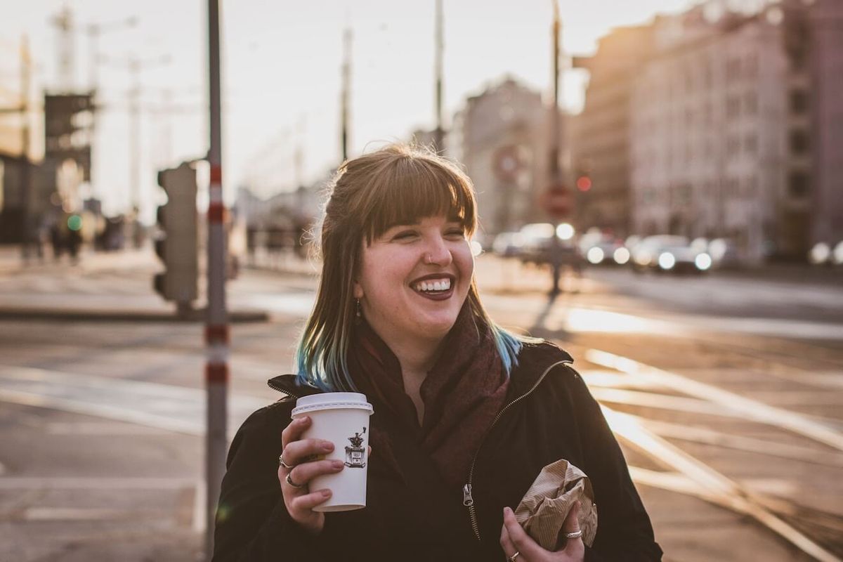 Kvinne, smiling, på gate, med, kaffe, og, bagel