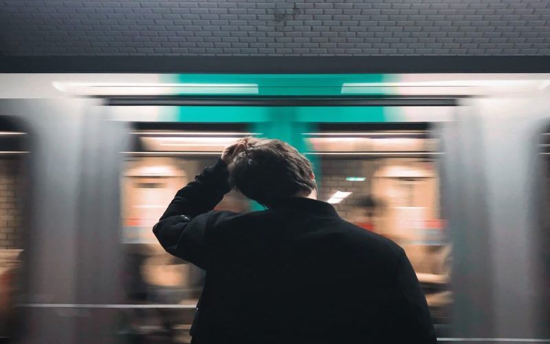 ストレスで髪を引っ張る地下鉄を待っている男